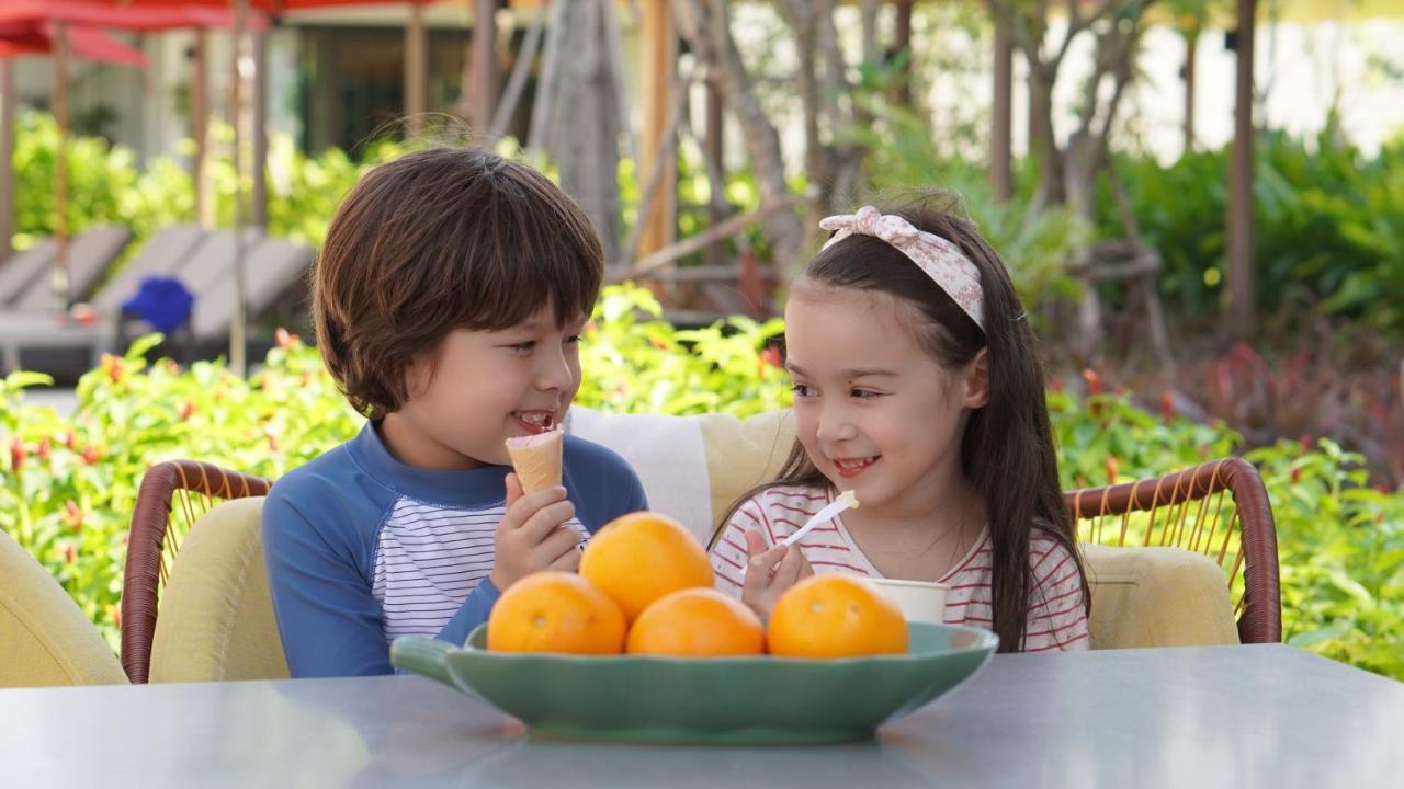 Hotel Amari Pattaya Esterno foto A boy and a girl eating fruit